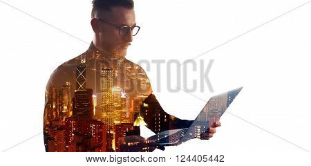 Double exposure bearded businessman wearing black shirt and glasses.Banker holding contemporary notebook hands, using online banking.Modern skyscraper city at night background.