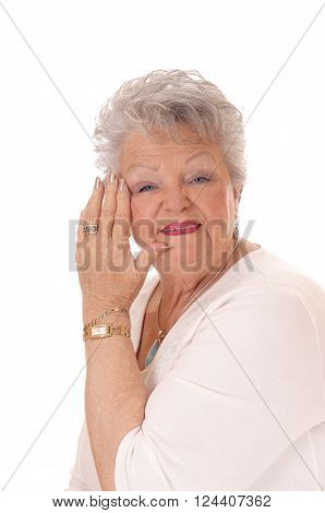 A beautiful senior woman with gray hair holding her hand on her face
isolated for white background.