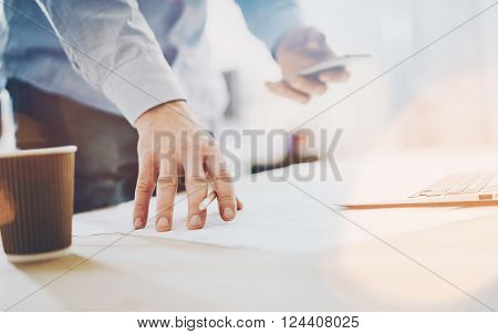 Photo work process banker.Man working wood table with new  business project.Modern laptop table.Pencil holding hand, typing  contemporary smartphone.
