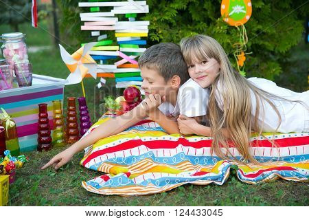 The boy and the girl on a mattress among fir-trees and toys