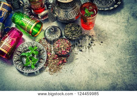 Tea with mint leaves and rose flower petals. Vintage style toned picture