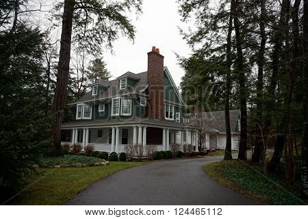 HARBOR SPRINGS, MICHIGAN / UNITED STATES - DECEMBER 23, 2015: A large white and green mansion in the private Glenn Woods Association in Harbor Springs, Michigan.