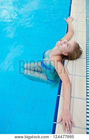 Unknown woman relaxing in the pool on a summer day resort