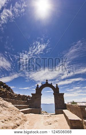 arch above titicaca lake in peru with blue sky and sky shining