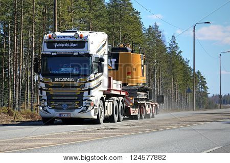 LOUKKU, FINLAND - APRIL 2, 2016: Scania R560 V8 Truck hauls CAT 325F L Medium Hydraulic Excavator along highway.