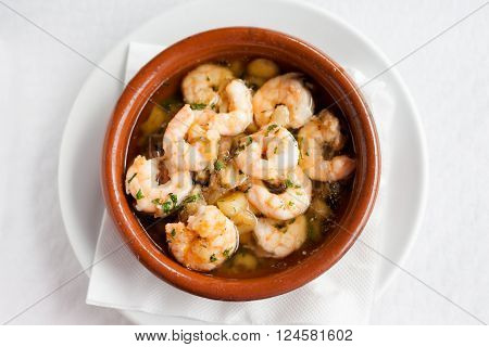 Fresh fried spanish garlic shrimp served in clay pot in local restaurant in Taganana on tropical island Tenerife Canary in Spain. Spanish food specialities.