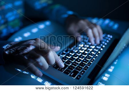 Close-up image of coder typing on computer