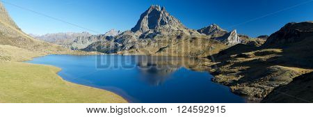 Midi Dossau Peak reflected in Gentau lake. Ossau Valley, Pyrenees National Park, Pyrenees, France.