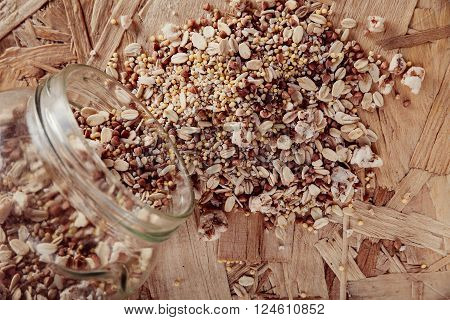 Collection Set of Cereal Grains: Millet Oat Corn Rice Buckwheat closeup shot on a wooden surface scattered from the bank the top view