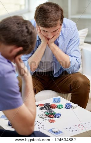 leisure, games, friendship, gambling and entertainment - close up of male friends playing cards at home