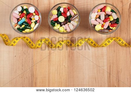 Tape measure and colorful medical pills capsules or supplements for therapy or weight loss concept of treatment health care and slimming copy space for text