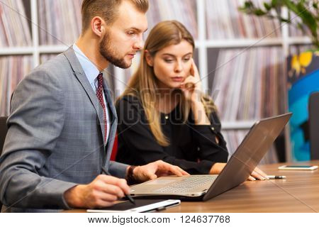      Two young business partners discussing plans or ideas at meeting 