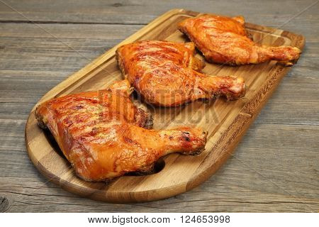 Three Grilled Bbq Chicken Leg Quarter On Wood Board