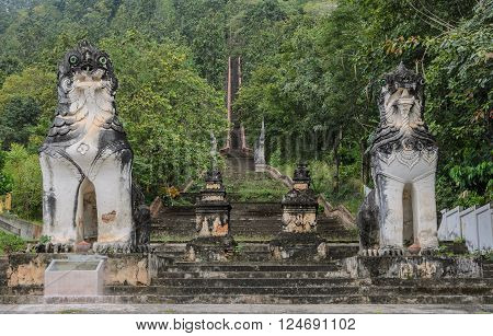 Burmese sculpted lions statue at stairways leading up to the hill at Wat Phra Non in Mae Hong Son, Thailand