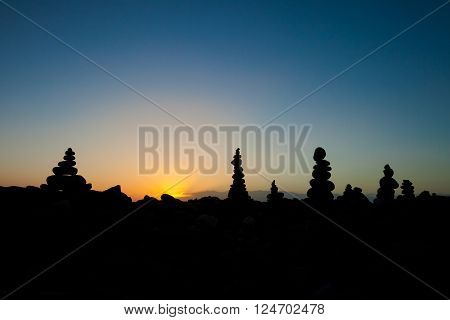 Summer sunset seascape with stone pile stacks silhouettes on tropical island Tenerife, Canary in Spain. Tranquil scene on Playa del Duque.