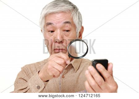 portrait of senior Japanese man with presbyopia on white background