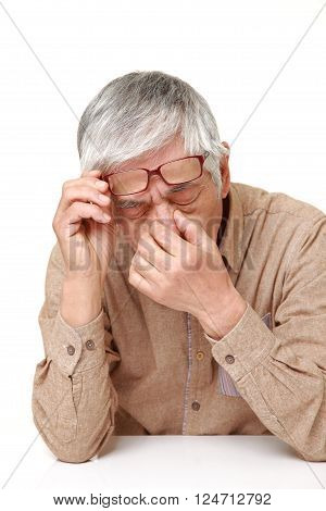 portrait of senior Japanese man suffers from Asthenopia