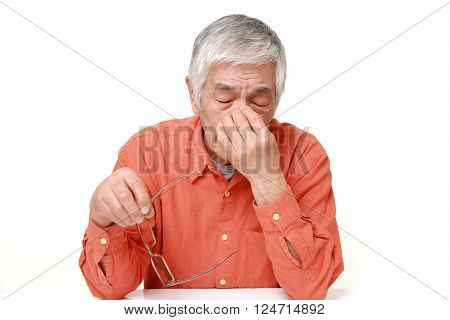 portrait of senior Japanese man suffers from Asthenopia