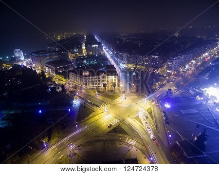 Aerial view of famous White Tower and the city of Thessaloniki at night Greece. Image taken with action drone camera causing distortion and blur.