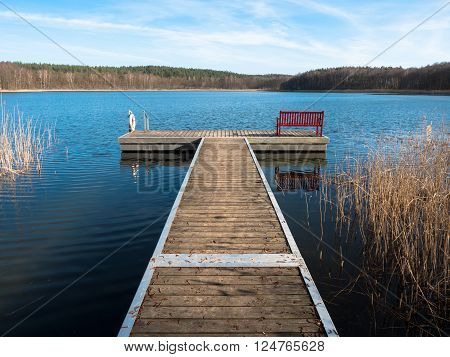 Dock with bench in a lake in spring