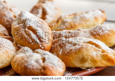 freshly baked apple pies on plate, wooden table