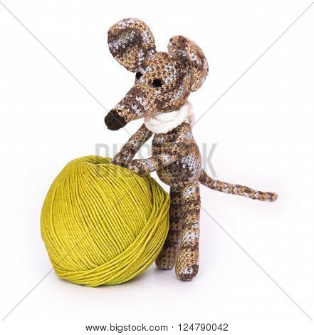 small colorful knitted toy mouse in a white scarf playing with colored yarn, threads of wool, Bright children's toy, clew