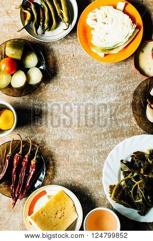Cucumber marinated bowl with pepper and garlic. Group of fermented veggies on the plate. Overhead view on vegetarian style dinner with vegetable soup pickled cucumbers pickled peppers cabbage.