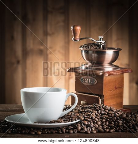 still life with coffee beans and old coffee mill on the wooden background 