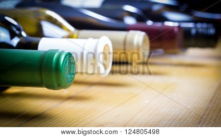 Wine bottles stacked on wooden racks shot with limited depth of field