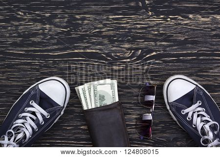 still life with sneakers, wallet with dollars and sungalsses