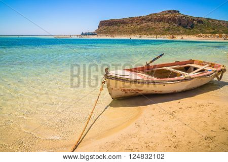 Fishing boat docked to coast on the beautiful beach of Crete Greece