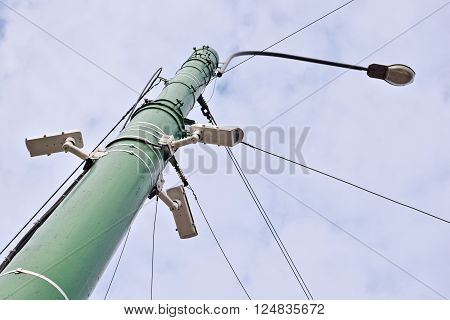 CCTV cameras and street lamp pole on blue sky background