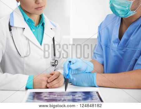 Portrait of male surgeon and woman dentist examining jaw radiation for diagnosis and teeth treatment. Health care ad medicine concept.
