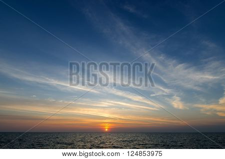 Beautiful colorful sunset over sea is reflected in mirror water of harbor