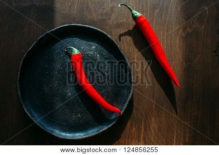red peppers red peppers on a clay plate Two red chili peppers red hot peppers on a brown background.
