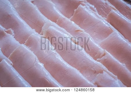 Ham slices on a plate on a self service breakfast counter in a hotel restaurant