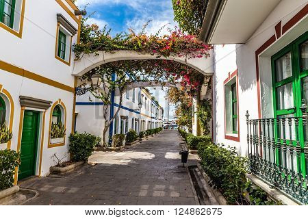 Traditional Narrow Street With White Buildings And Flowers- Puerto de Mogan Gran Canaria Canary Islands Spain