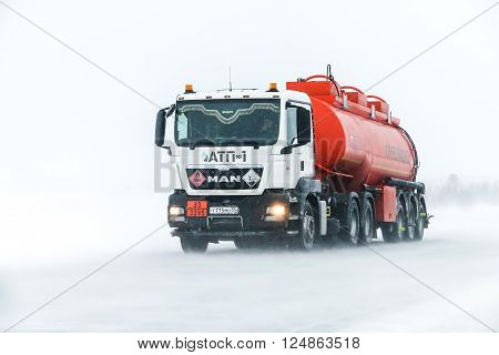 NOVYY URENGOY RUSSIA - MARCH 20 2016: Truck MAN TGS at the interurban freeway during a heavy northern blizzard.