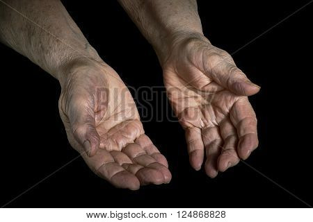 Senior woman hands open on a black background