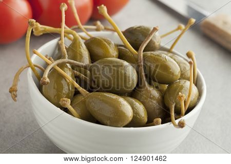 Bowl with pickled caperberries close up