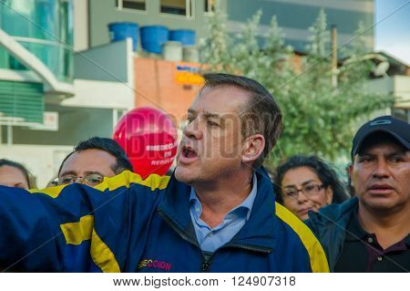 Quito, Ecuador - April 7, 2016: Closeup opposition leader Andres Paez surrounded by people, police and journalists during anti government protests in Shyris Avenue.