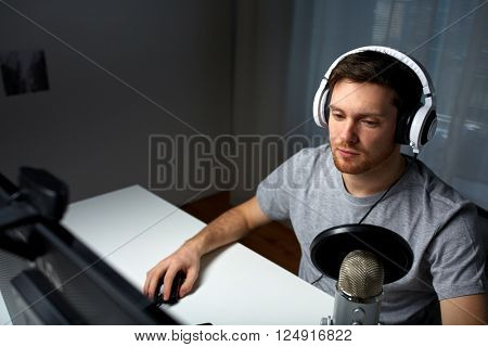 technology, gaming, entertainment, let's play and people concept - young man in headset with pc computer playing game at home and streaming playthrough or walkthrough video