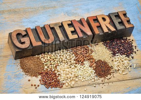 selection of gluten free grains (quinoa, rice, teff, buckwheat, sorghum,kaniwa, amaranth) and text in vintage letterpress wood type  against painted wood