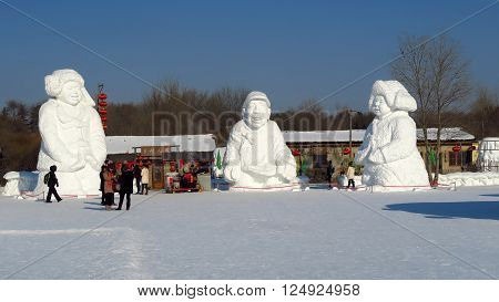 HARBIN CHINA - JANUARY 15 2016: people under snowy sculptures during the 32nd Harbin Ice Festival. The main attraction is the Harbin Ice and Snow World which covers more than 750000 square meters