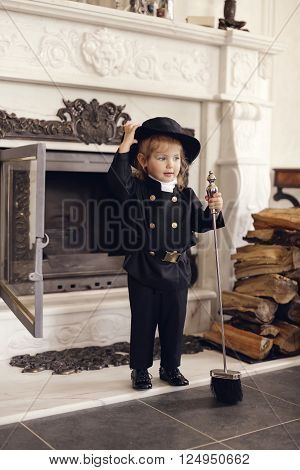 Girl as a chimney sweep against fireplace. Lucky New Year's Eve and New Year.