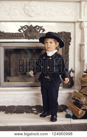 Girl as a chimney sweep against fireplace. Lucky New Year's Eve and New Year.