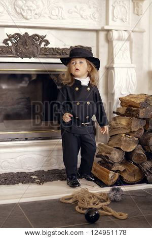 Girl as a chimney sweep against fireplace. Lucky New Year's Eve and New Year.