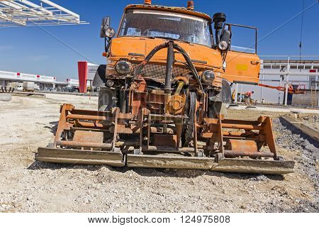 Plate compactor is mounted to the truck compacting sand at road construction site.