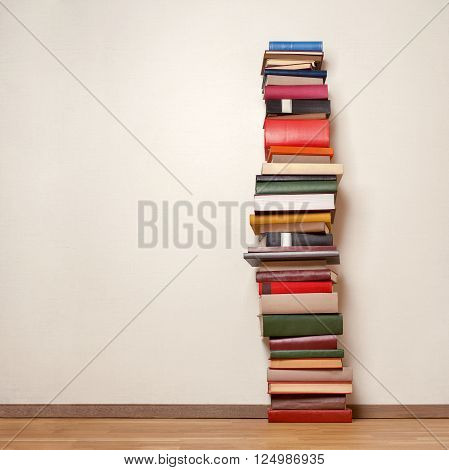 Big stack of old books on wooden floor