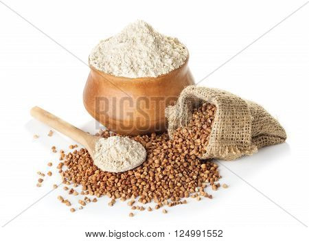 buckwheat flour in bowl and a bag a wooden spoon isolated on a white background closeup